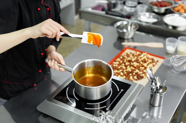 Panela de aço com caramelo fervente para fazer bombons