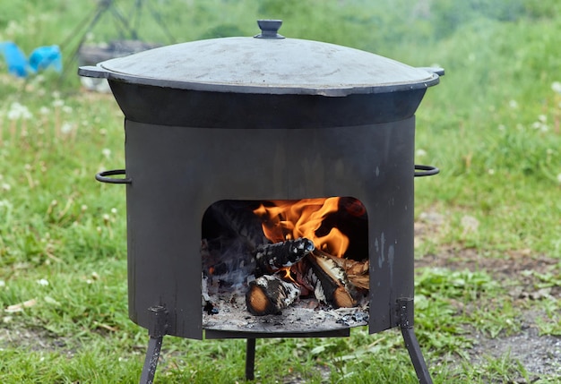 Panela de caminhada Bowler na fogueira no caldeirão na fogueira Turismo itinerante piquenique cozinhar cozinhar na fogueira em um caldeirão de fogo e fumaça