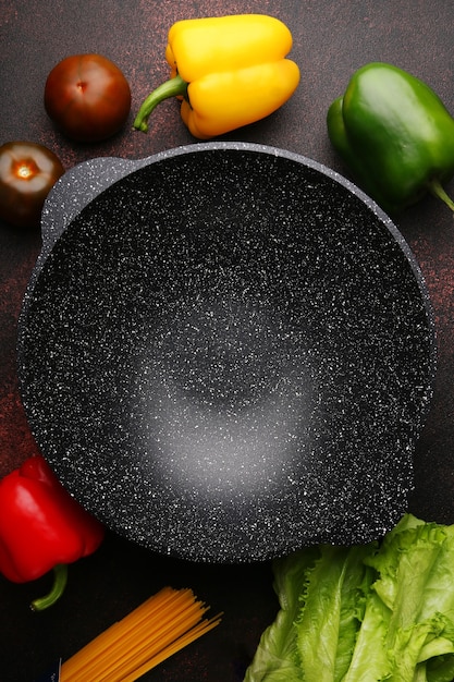 Panela wok vazia com ingredientes, legumes frescos e especiarias em fundo de metal culinário