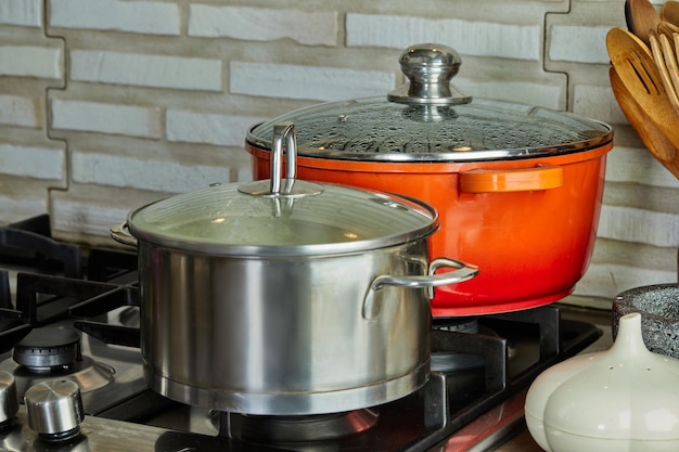 Panelas com cozinhar alimentos na cozinha no fogão a gás