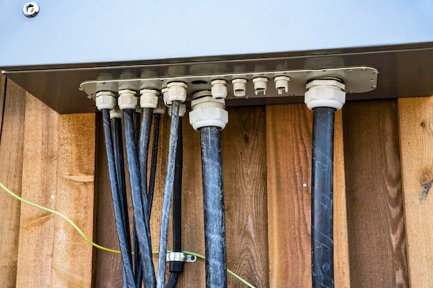 Paneles eléctricos y cables eléctricos conectados a ellos en la pared de la cabaña Suministro de electricidad a la construcción de la casa