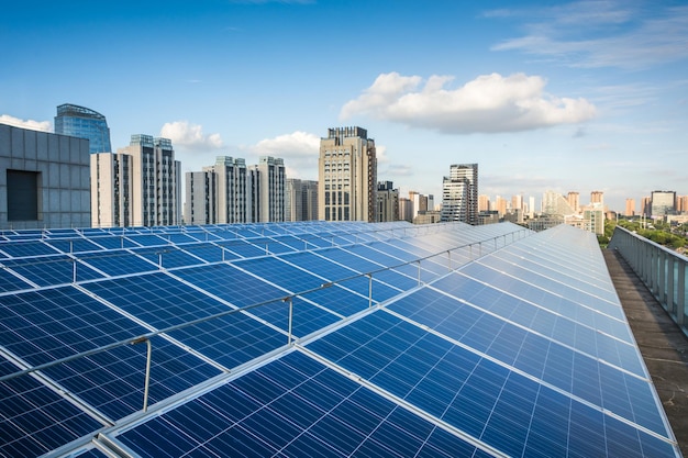 Paneles fotovoltaicos delante del fondo de la ciudad