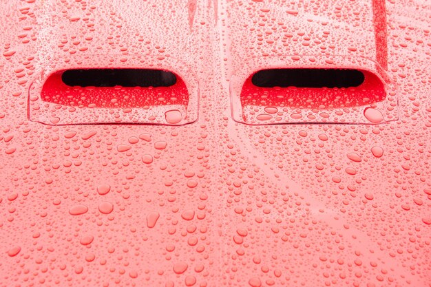 Foto paneles rojos de vehículos cubiertos de gotas de lluvia