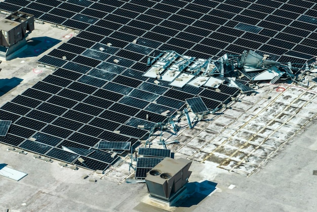 Paneles solares fotovoltaicos destruidos por el fuerte viento del huracán montados en el techo de un edificio industrial para producir electricidad ecológica verde Consecuencias del desastre natural en Florida