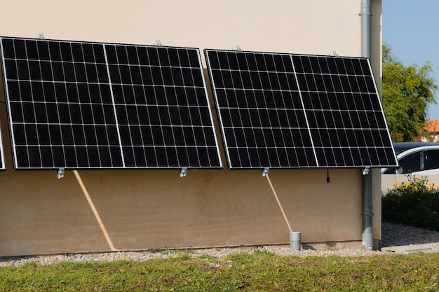 Paneles solares en una pared bien expuesta de una casa individual haciendo ahorros después de la crisis energética gesto ecocitizen energía verde