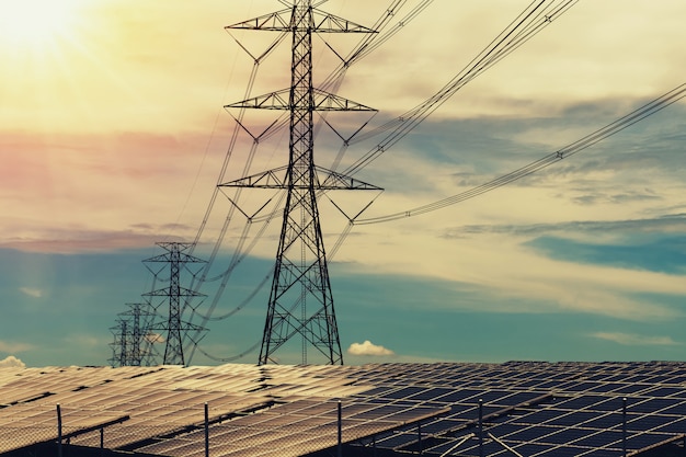 Paneles solares con pilón de electricidad y puesta de sol. Concepto de energía de energía limpia