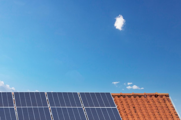Paneles solares en un techo en un día soleado y nublado Instalación fotovoltaica de energía solar limpia
