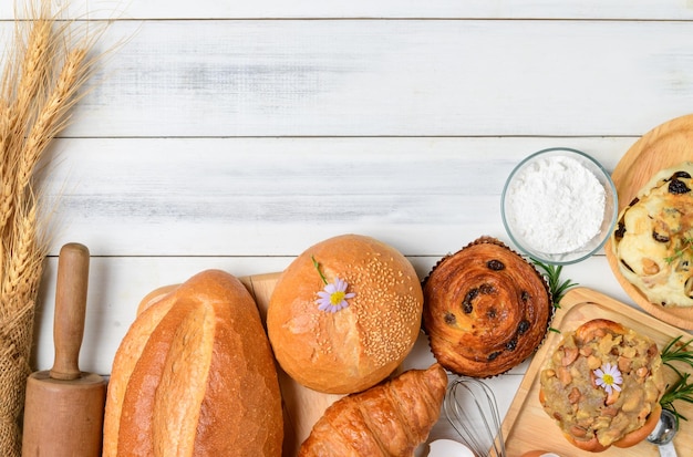 Foto panes caseros o bollo sobre fondo de madera croissant con masa fermentada y pastelería danesa desayuno y comida de panadería