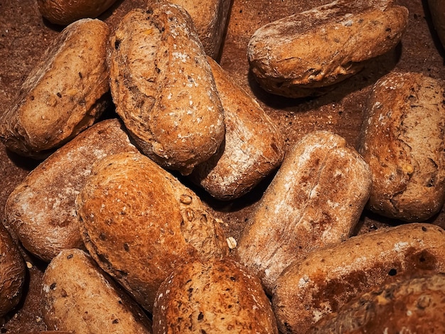 Panes frescos y bollos en productos horneados de panadería rústica sobre fondo rústico y mercado de alimentos de campo