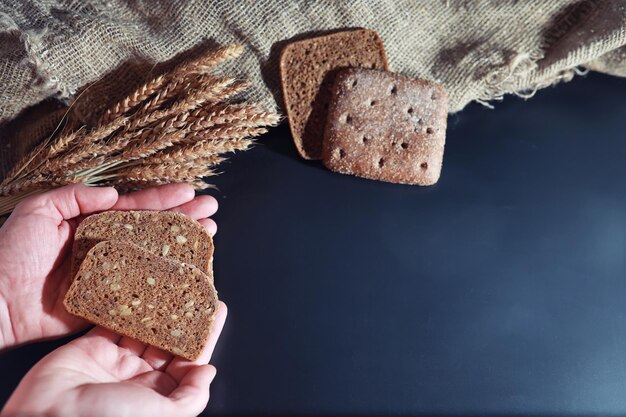 Panes frescos con trigo y gluten en una mesa negra Concepto de panadería y abarrotes Clases frescas y saludables de centeno y panes blancos Primer plano de alimentos Pan casero fresco con cereales