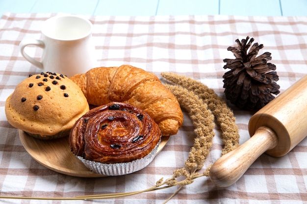 Panes o bollos caseros, croissant y rodillo sobre blanco, concepto de comida de desayuno y espacio de copia