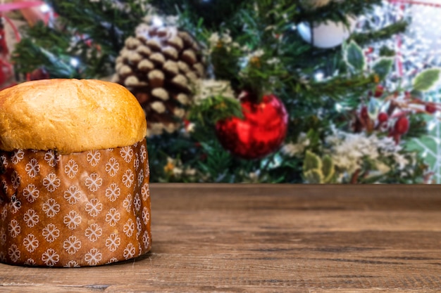 Panetone com fundo de natal, na mesa de madeira.