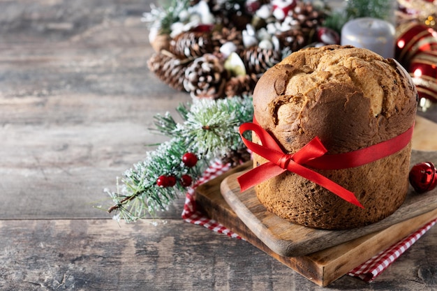 Panetone de natal tradicional com gravata vermelha na mesa de madeira