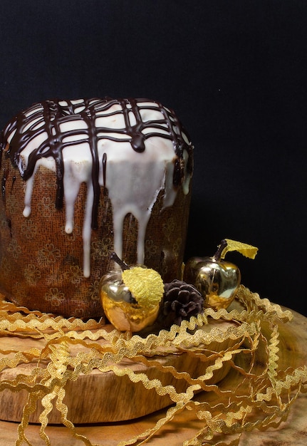 Panetone em uma mesa de madeira com fundo preto cercado por enfeites de Natal