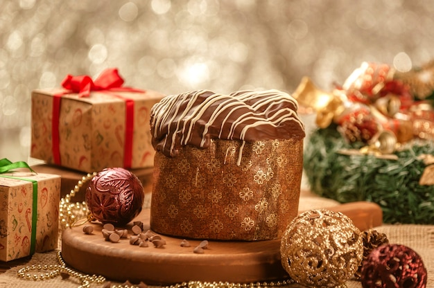 Panettone de chocolate sobre mesa de madera con adornos navideños