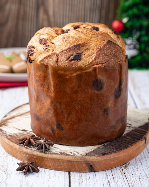 Panettone italiano tradicional con patatas de chocolate sobre una mesa de madera blanca