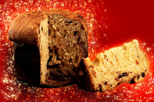 Panettone mit geschnittenem traditionellem Weihnachtslebensmittelstück mit rotem Hintergrund