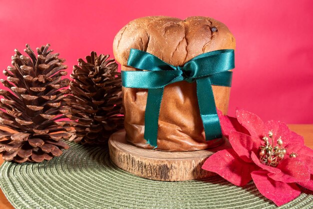 Foto panettone pan dulce italiano con frutas secas sobre un fondo rojo de navidad