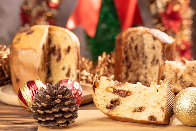 Panettone Panettone mit Schokoladenaromen auf einem rustikalen Tisch mit Weihnachtsdekorationen. Selektiver Fokus