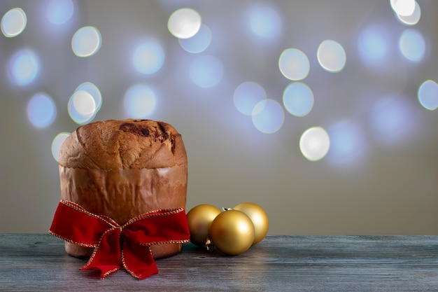 Panettone de pastel de chocolate navideño con una cinta roja en un fondo claro, panetone cho