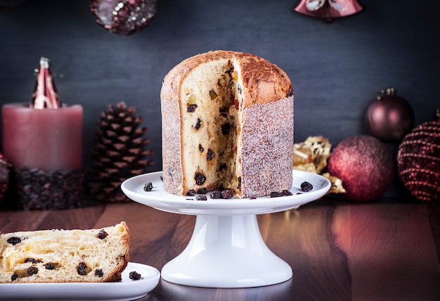 Panettone sobre una mesa de madera con decoración navideña, enfoque selectivo