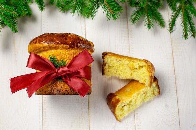 Foto panettone tradicional italiano pastel de frutas de navidad en un árbol de navidad blanco