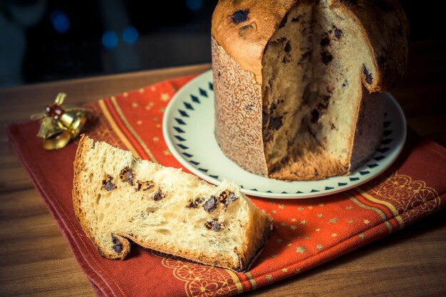 Panettone. Traditioneller italienischer Nachtisch für Weihnachten mit chistimas beleuchten auf Hintergrund