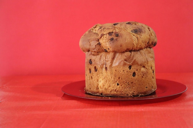 Panettone, typisch italienische Süßigkeit zu Weihnachten mit rotem Hintergrund