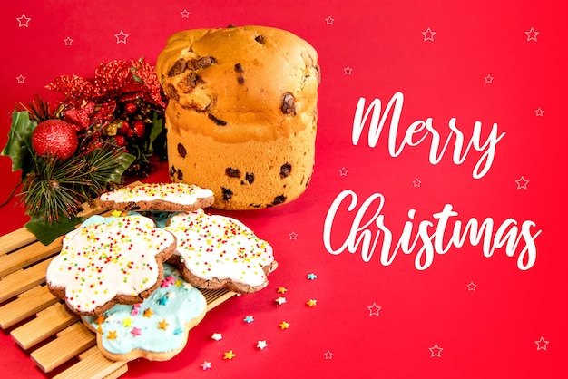 Panettone und Weihnachtsplätzchen auf rotem Grund. Weihnachtsdessert.