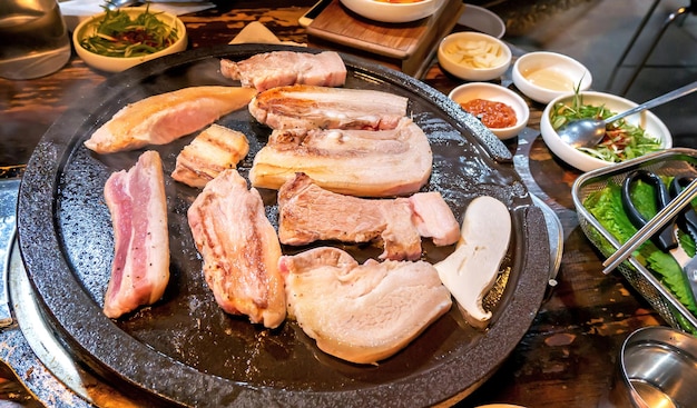 Panfried comida de cerdo negro cocido en el restaurante de Corea cocina fresca deliciosa comida coreana en placa de hierro con lechuga espacio de copia de cerca estilo de vida