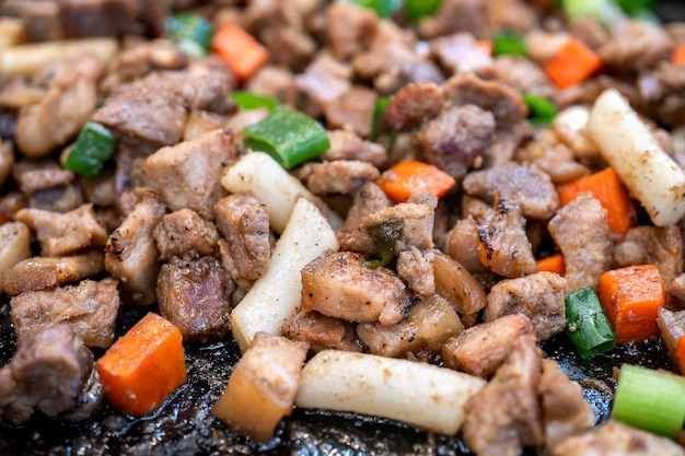 Panfried comida de cerdo negro en el mercado tradicional de Corea deliciosa cocina de comida coreana con zanahoria y cebolla verde chalota cerrar espacio de copia