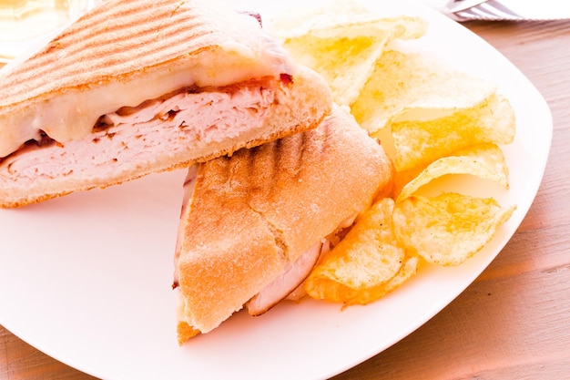 Panini de almuerzo con patatas fritas a un lado.