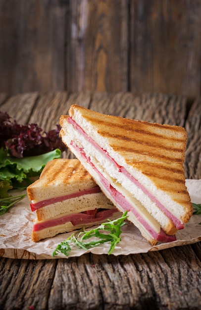 Panini com presunto e queijo na mesa de madeira