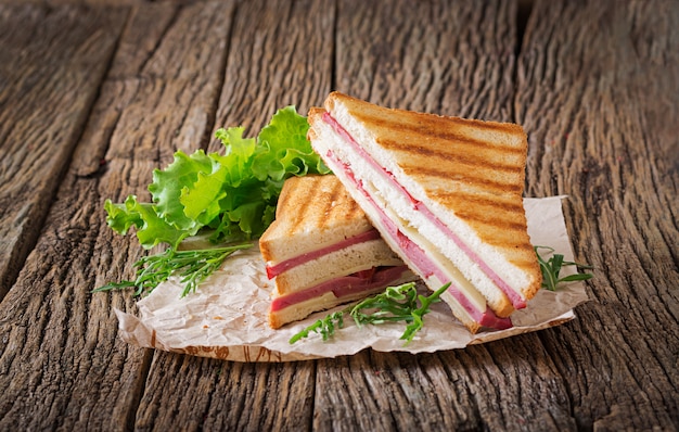 Panini com presunto e queijo na mesa de madeira