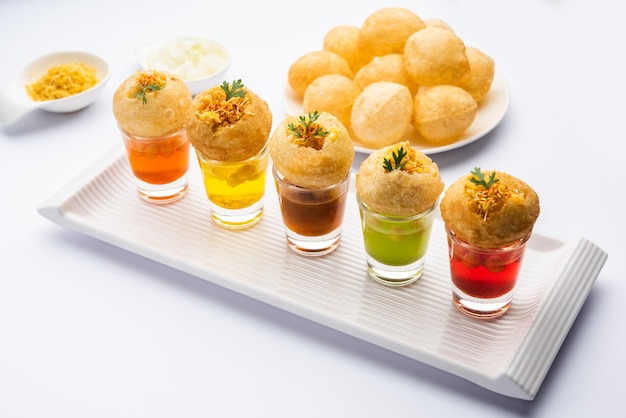 Panipuri-Shot oder Golgappa-Shots mit verschiedenen Wasseraromen, serviert in kleinen Gläsern mit gefülltem Puri-Indischer Vorspeise-Snack