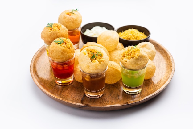 Panipuri-Shot oder Golgappa-Shots mit verschiedenen Wasseraromen, serviert in kleinen Gläsern mit gefülltem Puri-Indischer Vorspeise-Snack