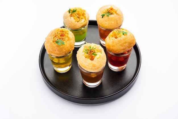 Panipuri shot ou Golgappa Shots diferentes sabores de água servidos em copos pequenos com aperitivo indiano puri recheado