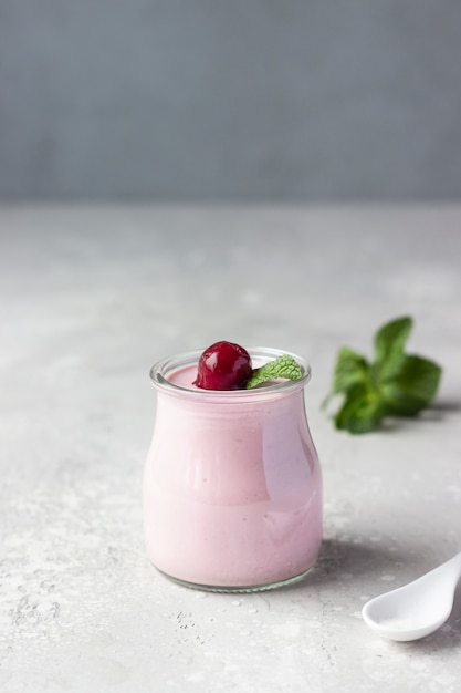 Foto panna cotta de cerezas con cerezas frescas y menta en frascos