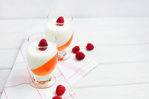 Panna cotta deliciosa sobremesa italiana com geléia de baga na superfície de madeira