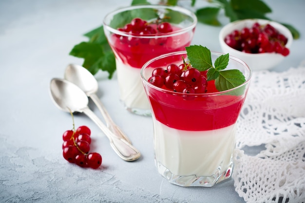 Panna cotta con gelatina de grosellas rojas en vidrio vintage con hojas