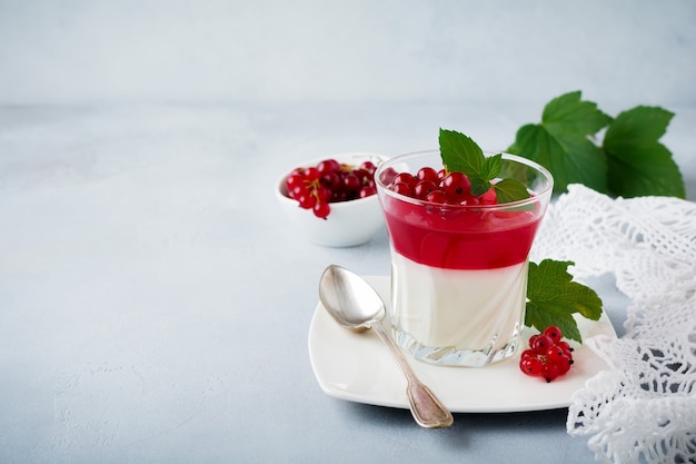 Panna cotta con gelatina de grosellas rojas en vidrio vintage con hojas