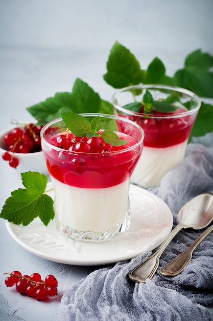 Panna cotta con gelatina de grosellas rojas en vidrio vintage con hojas