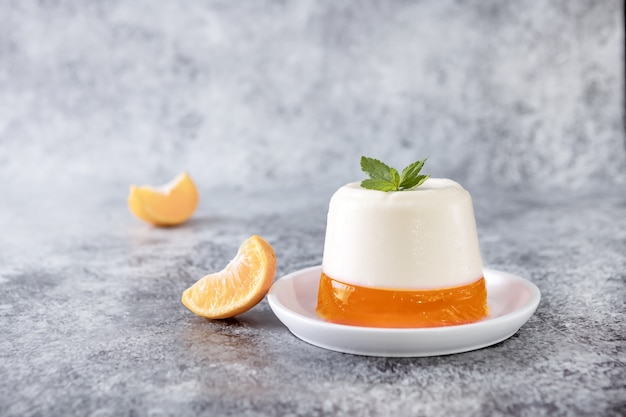 Panna cotta de postre italiano con gelatina de mandarina y menta