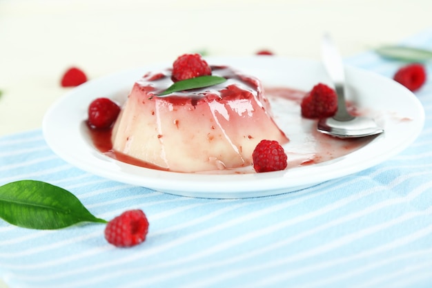 Panna Cotta con salsa de frambuesa sobre fondo de madera