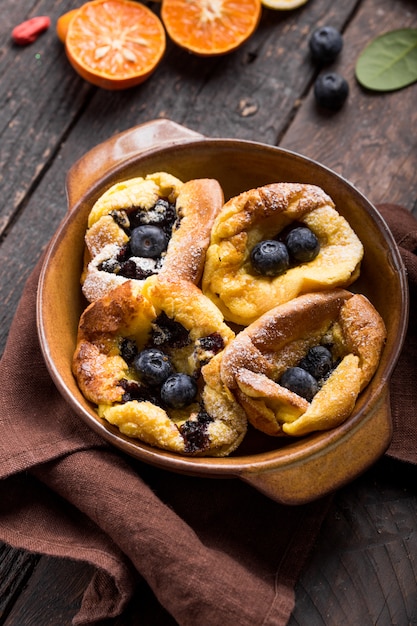 Pannukakku oder dänischer Pfannkuchen mit Beeren, die mit Zuckerpulver bedeckt sind