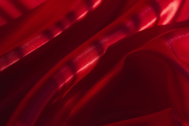 Foto pano brilhante de cor vermelha para o fundo. pano brilhante de cor vermelha, fundo romântico de luxo, maquete de tecido tem rugas e sombra