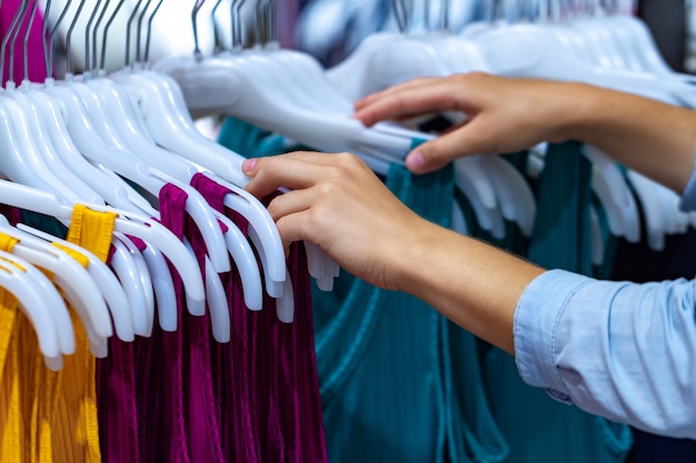 Pano de compra no mercado de segunda mão no shopping. Vendas e descontos. Mulher às compras no shopping da moda, escolhendo roupas novas para atualização do guarda-roupa