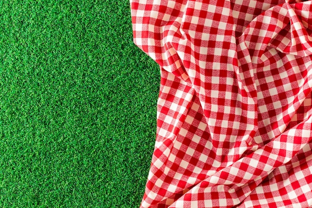 Foto paño de mesa rojo sobre fondo de hierba verde