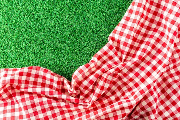 paño de mesa rojo sobre fondo de hierba verde