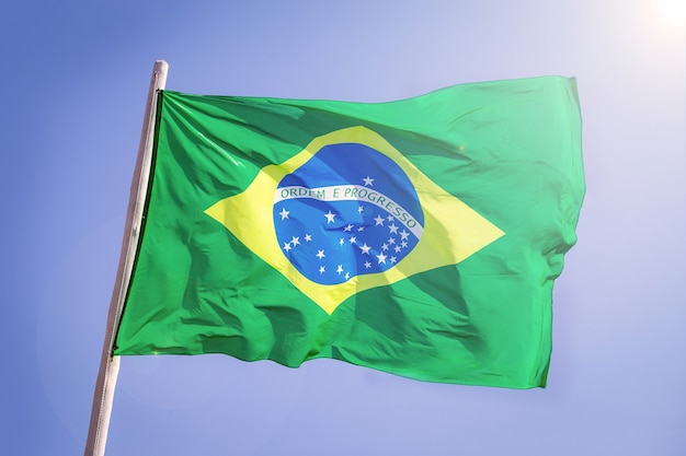 Pano têxtil da bandeira nacional do brasil acenando no topo, céu azul brasil, conceito de patriotismo